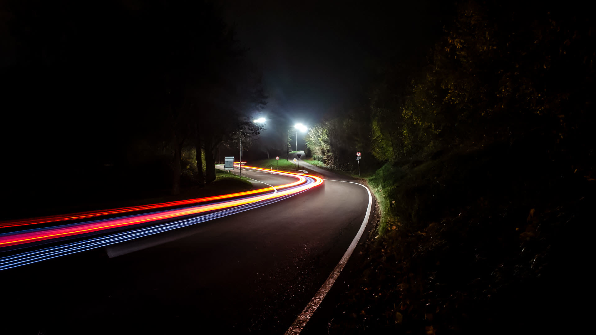 Langzeitbelichtung einer Landstraße bei Nacht